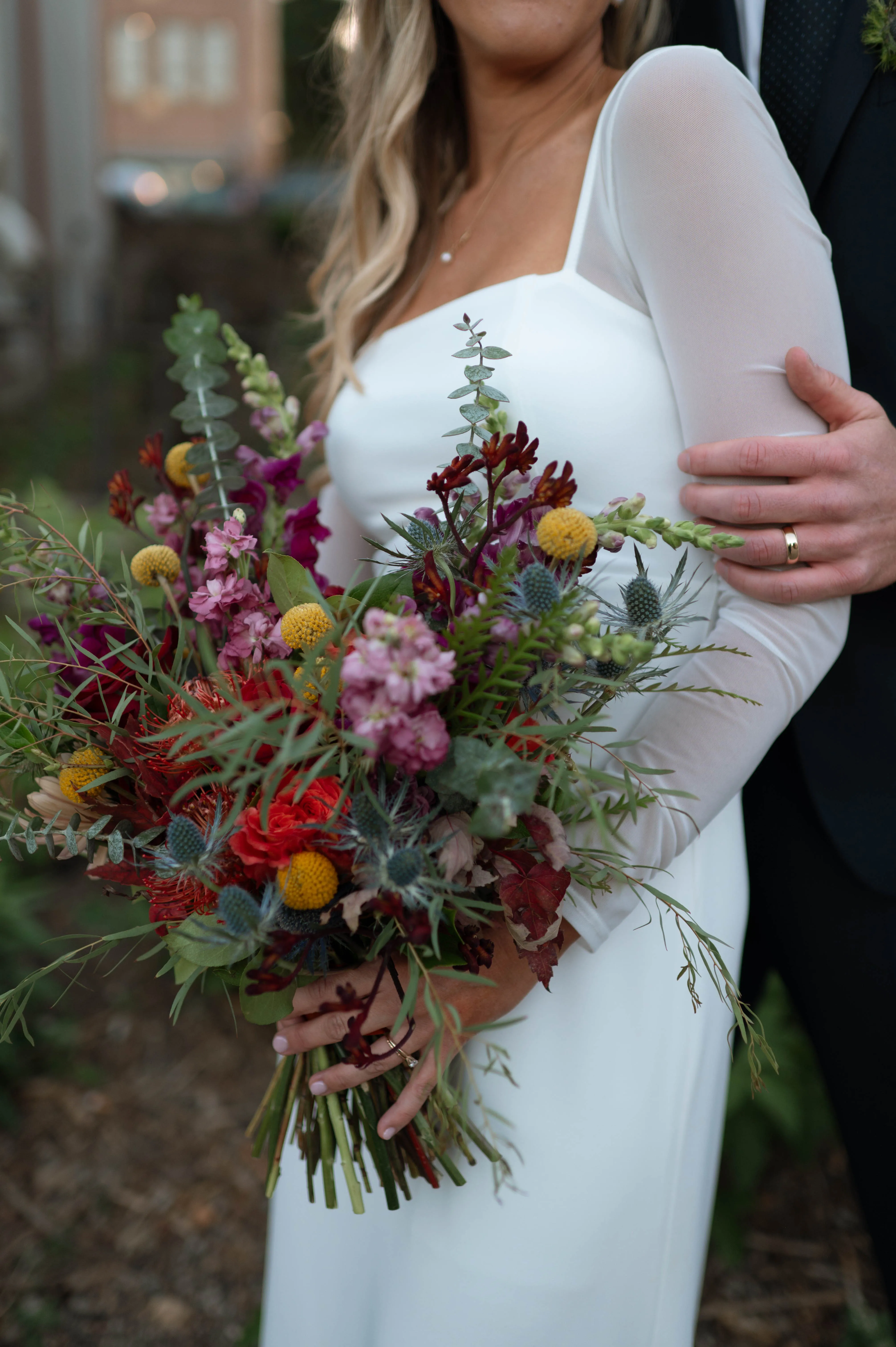 Close-up of a jewel-toned bouquet in wine, amber, and burgundy