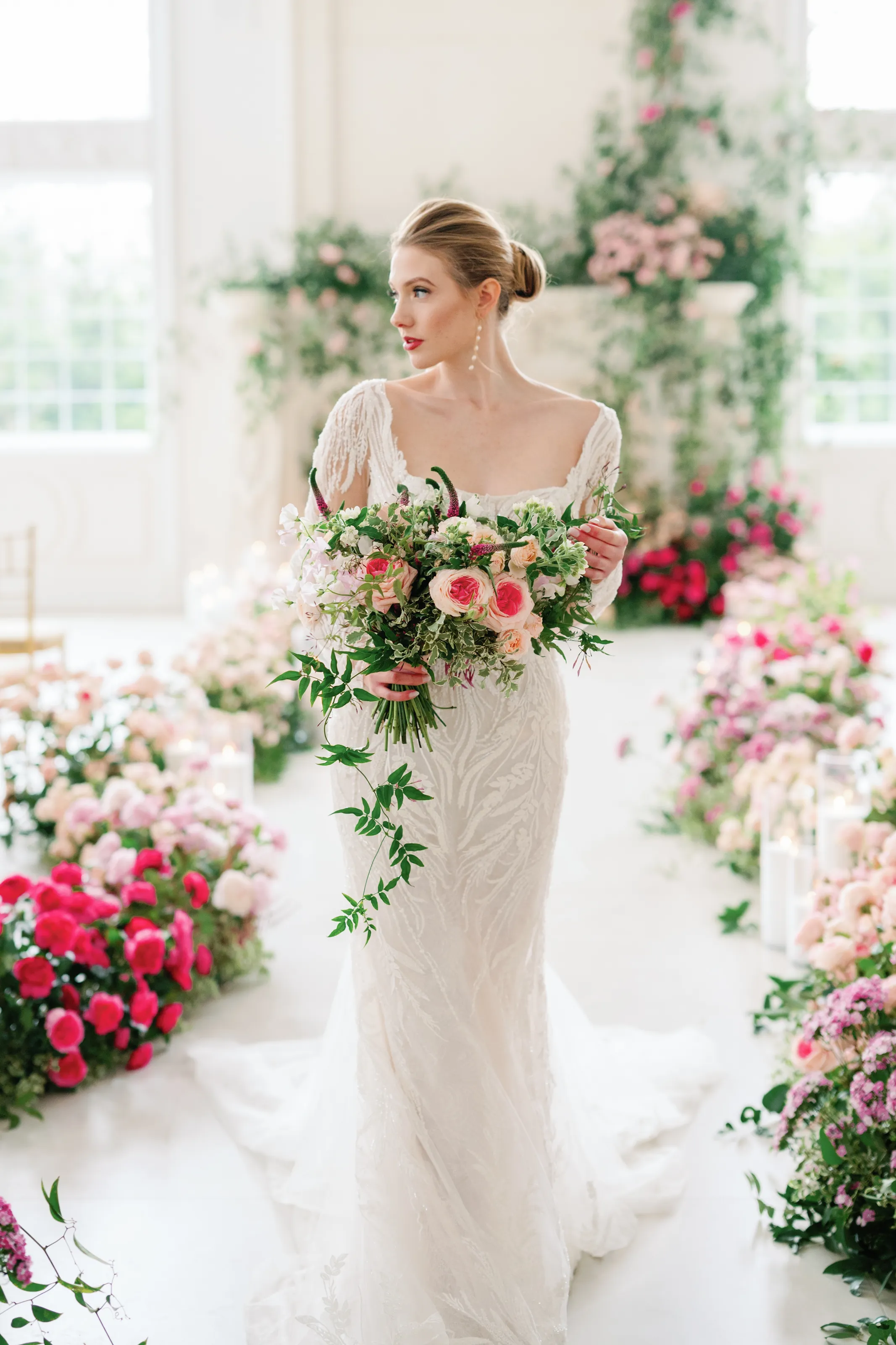 A bridal portrait in the rose-lined ceremony space, bouquet of garden roses and sweet pea in hand