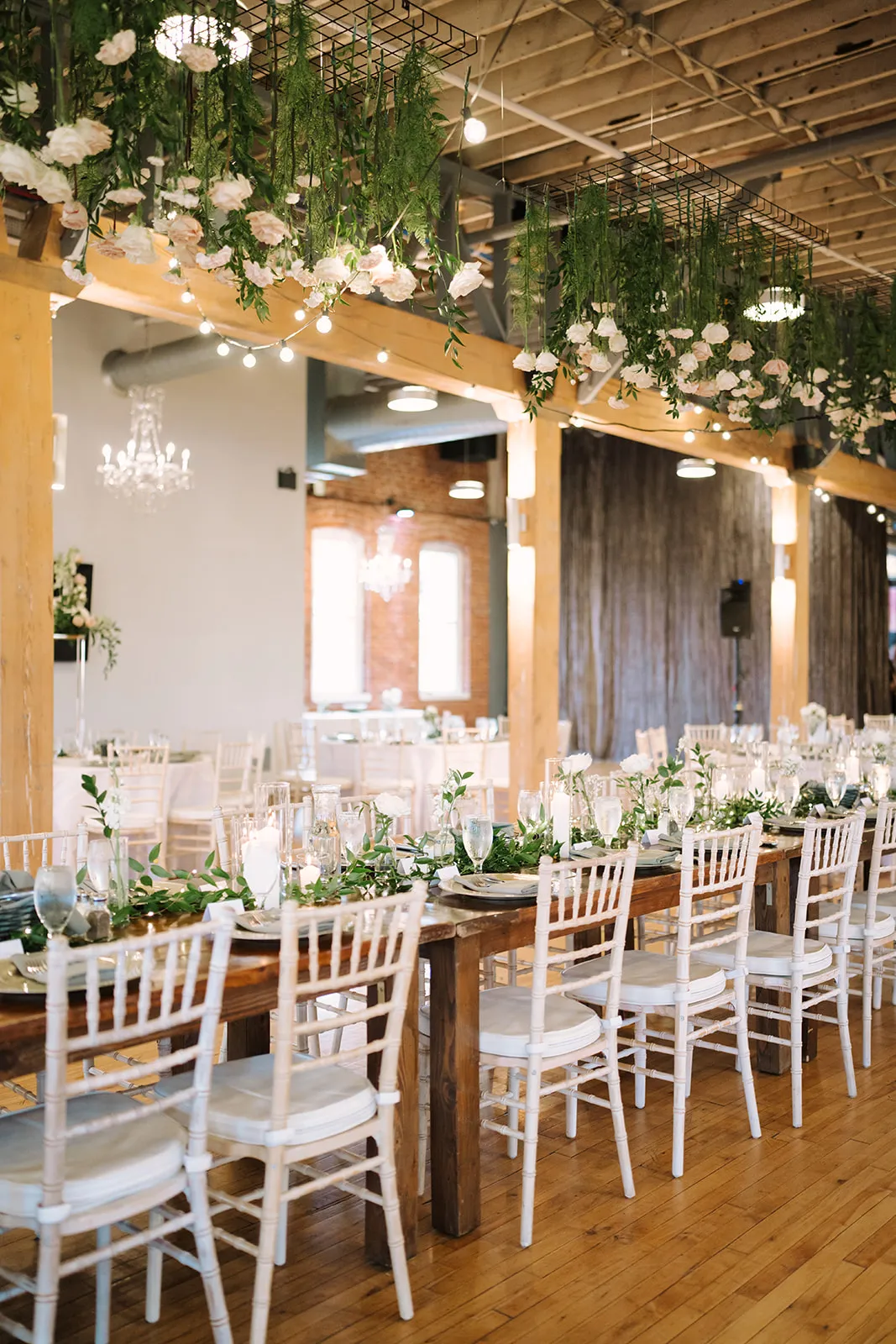 A long reception table set with candlelight and trailing greenery