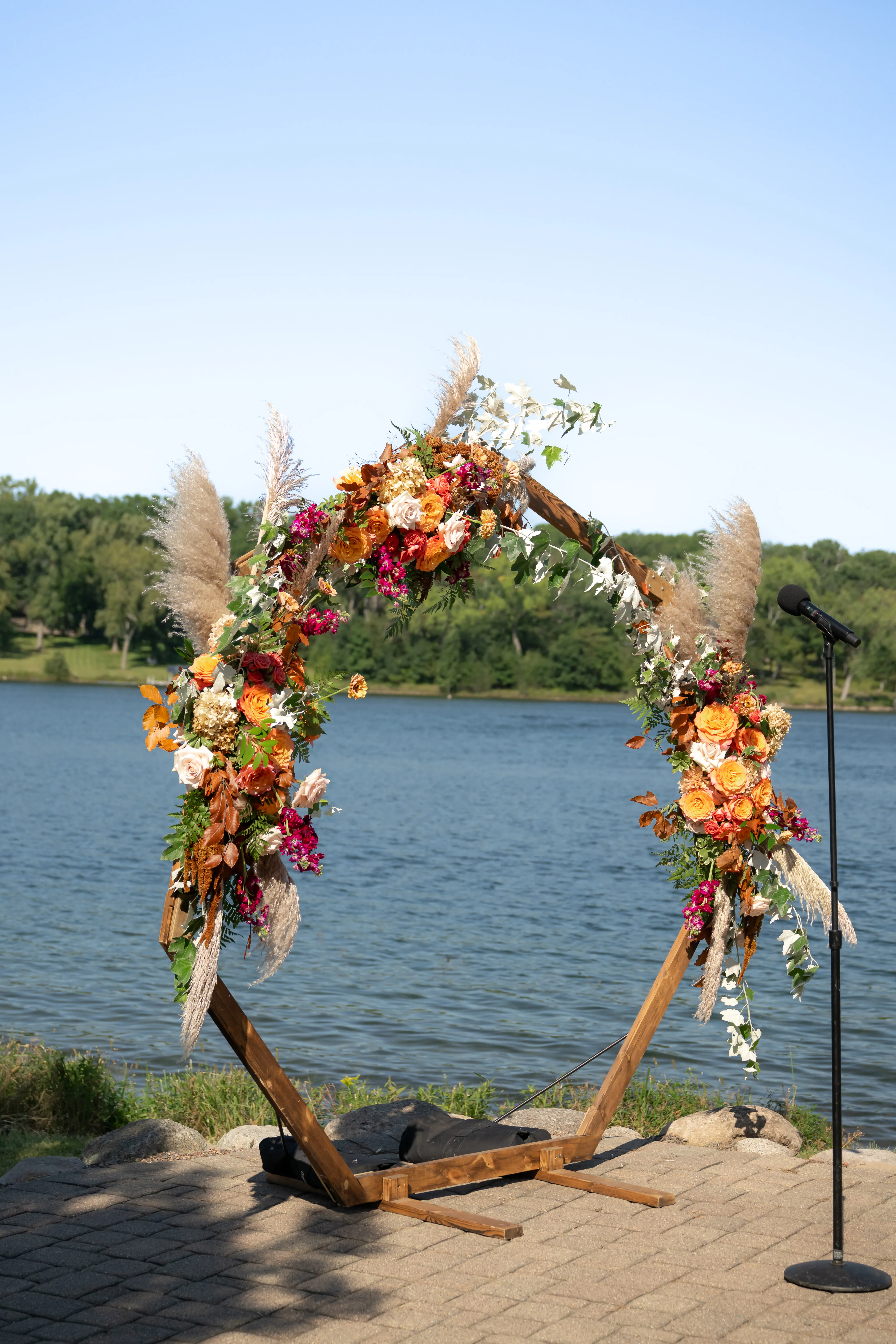 Detail of the hexagon arbor's pampas grass, orange, and magenta blooms against the lake