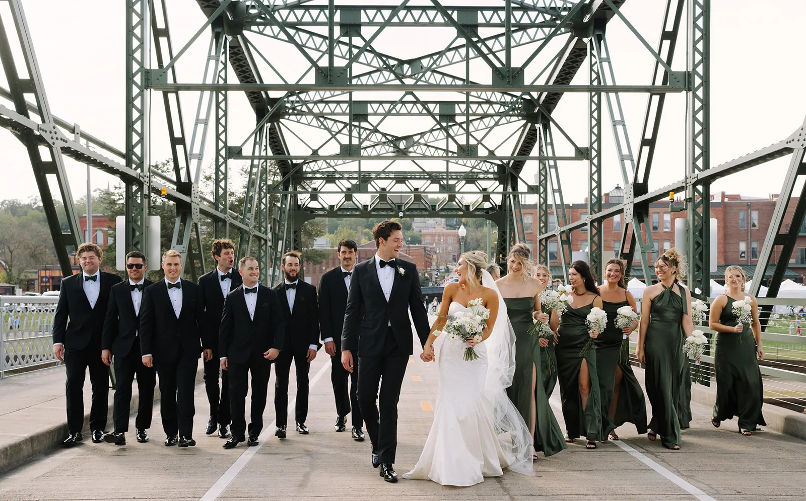 The wedding party walking across the lift bridge in downtown Stillwater